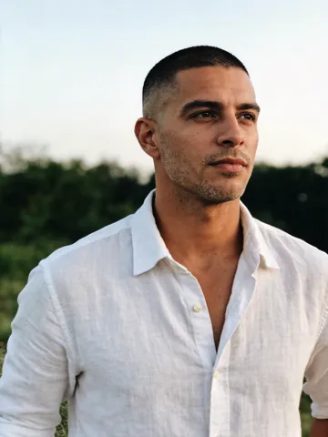 Input photo: a man with a short fade in a white linen shirt